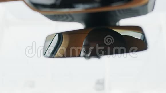 近距离男子调整后视镜在汽车坐在车前的非洲男人视频的预览图