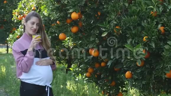 孕妇在户外喝橙汁视频的预览图