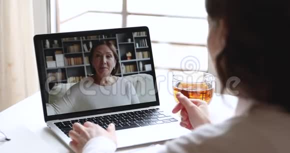 年轻女子在笔记本电脑屏幕上打电话给年长母亲的视频视频的预览图