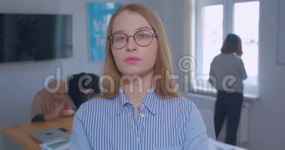 一幅年轻漂亮自信自豪的白种人金发眼镜办公室背景肖像视频的预览图