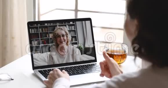 快乐的大妈妈和小女儿视频通话笔记本电脑屏幕视频的预览图