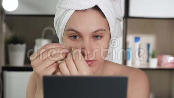 拍眼睛浴室里有魅力的女人头上有毛巾眼睛下面有透明的皮肤视频的预览图