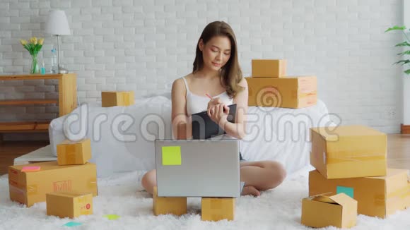 一位年轻的亚洲女性在家中闲逛一位在家中使用笔记本电脑进行网上购物的女商人视频的预览图