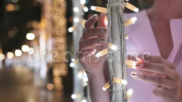 女孩轻轻地触摸着迪拜夜城一棵棕榈树上发光的灯光视频的预览图