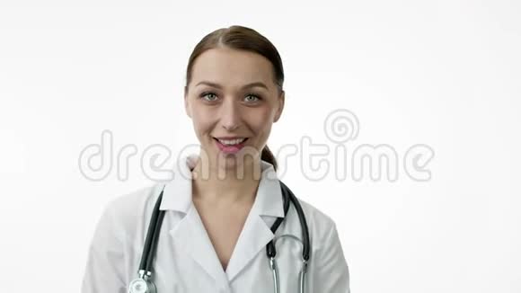 快乐美丽的女医生在白色的背景上跳舞微笑玩得开心视频的预览图