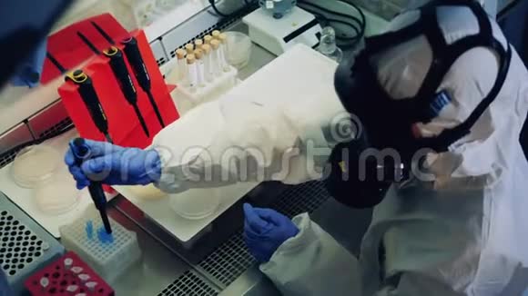 科学家测试了covid19冠状病毒的样本一位穿防毒服的专家正在实验室里研究探测器视频的预览图