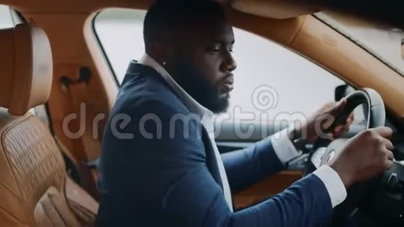 侧视男子坐在方向盘后的汽车非洲男人在车上跳舞视频的预览图