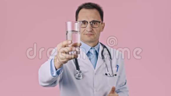 中年医生拿起一杯干净的水用拇指显示就像一个标志视频的预览图