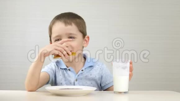 孩子喝牛奶吃三明治这个男孩吃了一个夹心巧克力糊喝了一杯牛奶健康视频的预览图