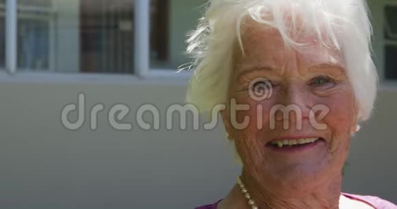 老妇人微笑着看着摄像机视频的预览图