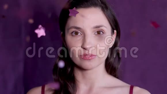 女人站在工作室的紫色背景和纸屑视频的预览图
