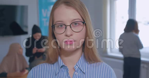 一幅年轻美丽悲伤的白种人金发眼镜办公室背景肖像视频的预览图