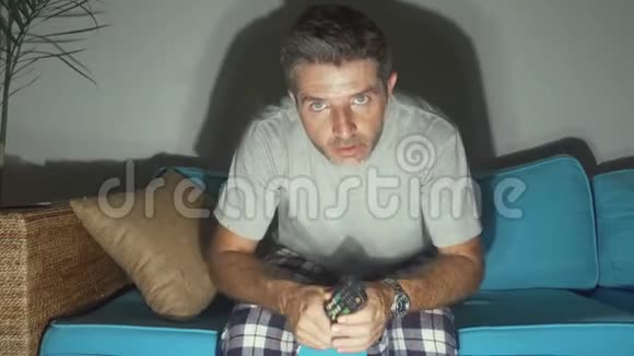 在电视上看恐怖电影坐在紧张的家沙发上抱着枕头视频的预览图