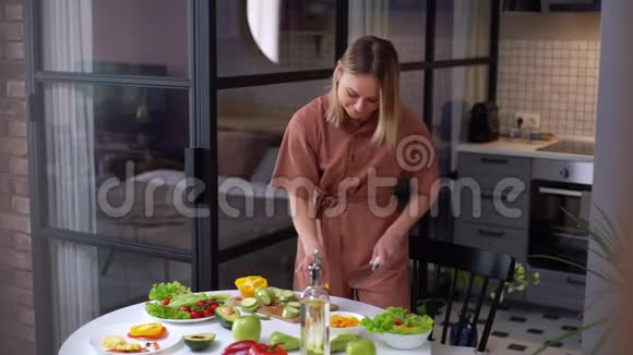 幸福的年轻女子素食者独自在家准备沙拉餐视频的预览图