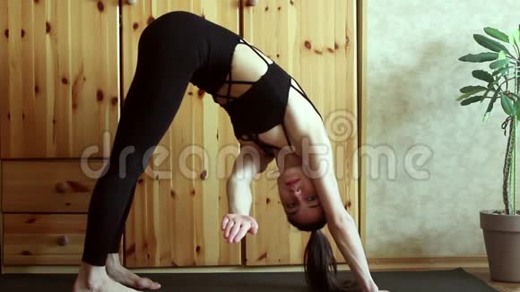 一个漂亮的年轻女孩在家练习瑜伽一个年轻漂亮的女孩表演体式改善了她的身体视频的预览图