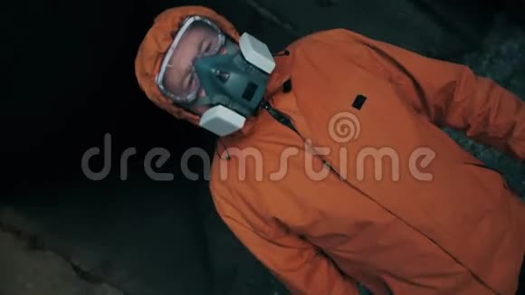 一个戴着呼吸器穿着特殊工作服的人从一个混凝土掩体里出来视频的预览图