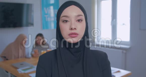 一个年轻漂亮的白种人女孩在头巾办公室背景的肖像视频的预览图