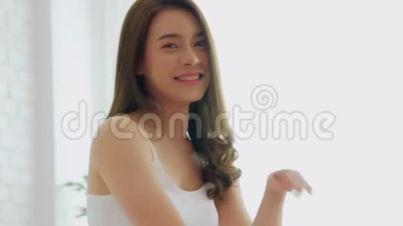 美丽迷人的亚洲年轻女子微笑拥抱枕头视频的预览图