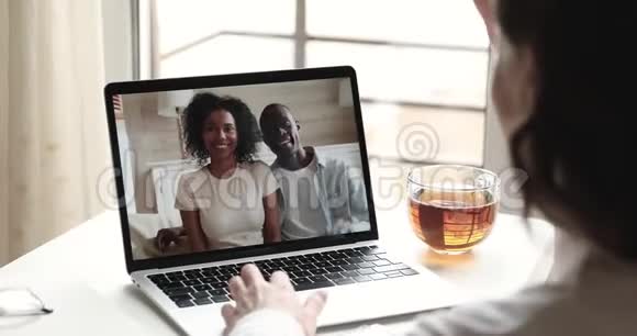 快乐的白种人女人视频打电话给非洲朋友情侣笔记本电脑视频的预览图