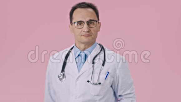 穿着医用外套和听诊器的有吸引力的医生用粉笔心显示药片视频的预览图