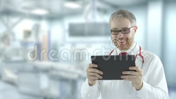 医生使用他的平板电脑进行远程医疗呼叫红色摄像机拍摄视频的预览图