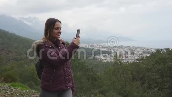 年轻女子带着电话走在山里视频的预览图