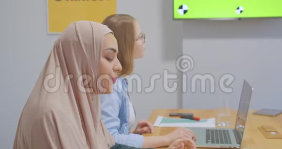 四个自信开朗多元化的同事办公室女头巾讨论商业计划展示色彩艳丽的笑声视频的预览图