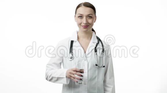 年轻的女医生拿着一杯干净的水像拇指朝上的标志视频的预览图