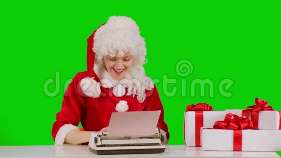 有趣的圣诞女人在打字机上写信在绿色上孤立很多花环圣诞节寒假和视频的预览图