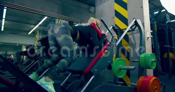 运动员女孩正在体育馆里用压腿机进行运动视频的预览图