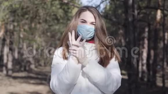自信的年轻女子戴着防护面罩和手套在阳光明媚的春天在户外摆姿势高加索女孩肖像视频的预览图