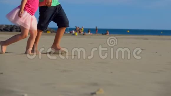 一个男孩和女孩在海滩边牵着手的时候拍腿视频的预览图
