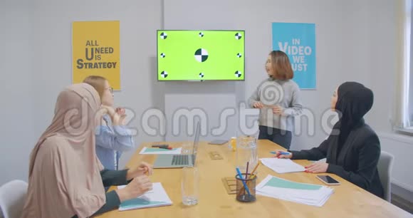 四位自信开朗多元化的同事办公室女头巾讨论商业计划呈色亚洲人视频的预览图
