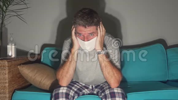 covid19病毒感染症状戴口罩的恐惧和焦虑的男人在家里沙发上感到恶心咳嗽和胸痛视频的预览图