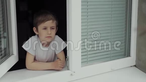 一个5岁的男孩独自一人在窗前带着百叶窗视频的预览图