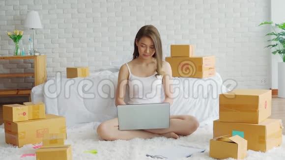 一位年轻的亚洲女性在家中闲逛一位在家中使用笔记本电脑进行网上购物的女商人视频的预览图