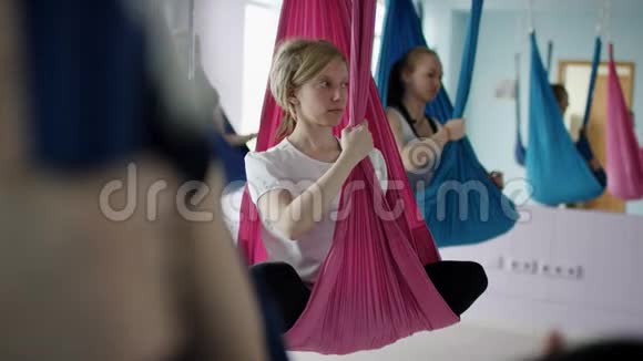 女人在吊床上练习瑜伽空中瑜伽工作室视频的预览图