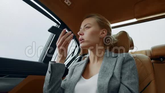 女商人在后座讲电话微笑的女人在车上打电话视频的预览图