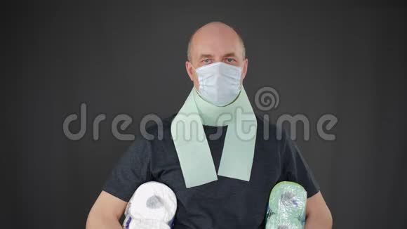 成年男子肖像戴防护面具脸上拿着卫生纸在腋下戴医疗口罩的男子视频的预览图