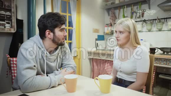 年轻夫妇在厨房里一起聊天喝茶视频的预览图