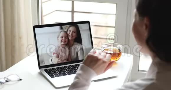 女妈妈在电脑屏幕上给女儿和保姆打电话视频的预览图