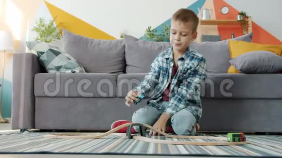 在公寓里玩玩具车的无忧无虑的男孩在家里玩游戏视频的预览图