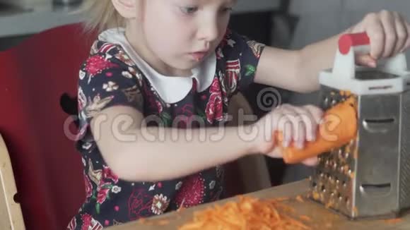厨房里一个小女孩在家里的烤炉上搓胡萝卜视频的预览图