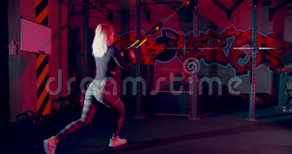 女运动员在体育馆做TRX缆绳单腿下蹲仰视图视频的预览图