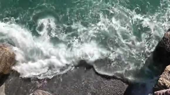 水沫从接近海岸的海浪中涌来视频的预览图