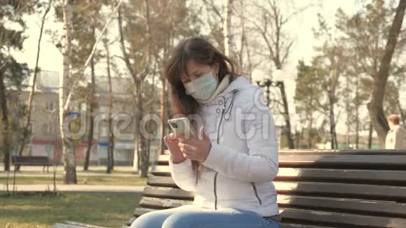 冠状病毒保护一位戴着医用防护面罩的年轻女士正坐在欧洲的城市街道上视频的预览图