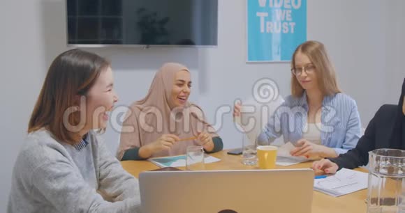 四个自信开朗多元化的同事办公室女头巾讨论商业计划笑笑笑视频的预览图