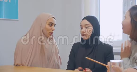三位办公室通信中断的同事使用智能手机多种多样快乐的笑话hijab亚洲视频的预览图