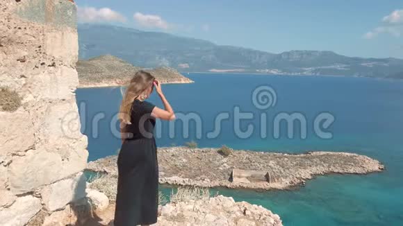 女人来到海边的悬崖边视频的预览图