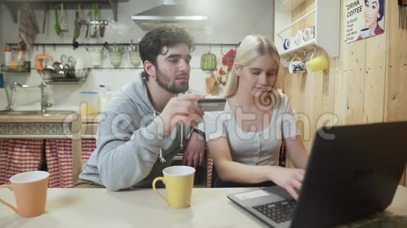 年轻人和女人正在网上购买笔记本视频的预览图